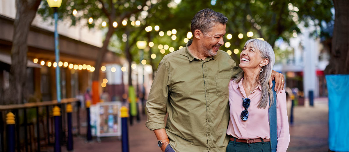 man and woman walking past shops